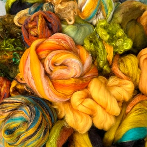 May include: A close-up of a collection of colorful yarn in various shades of yellow, orange, green, and blue. The yarn is in different forms, including skeins, roving, and loose fibers, ideal for fiber art projects.
