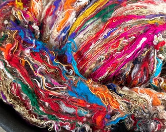 May include: A close-up of a large ball of colorful yarn. The yarn is made of a variety of fibers, including silk, wool, and cotton. The yarn is a mix of bright colors, including red, orange, yellow, green, blue, purple, and pink.