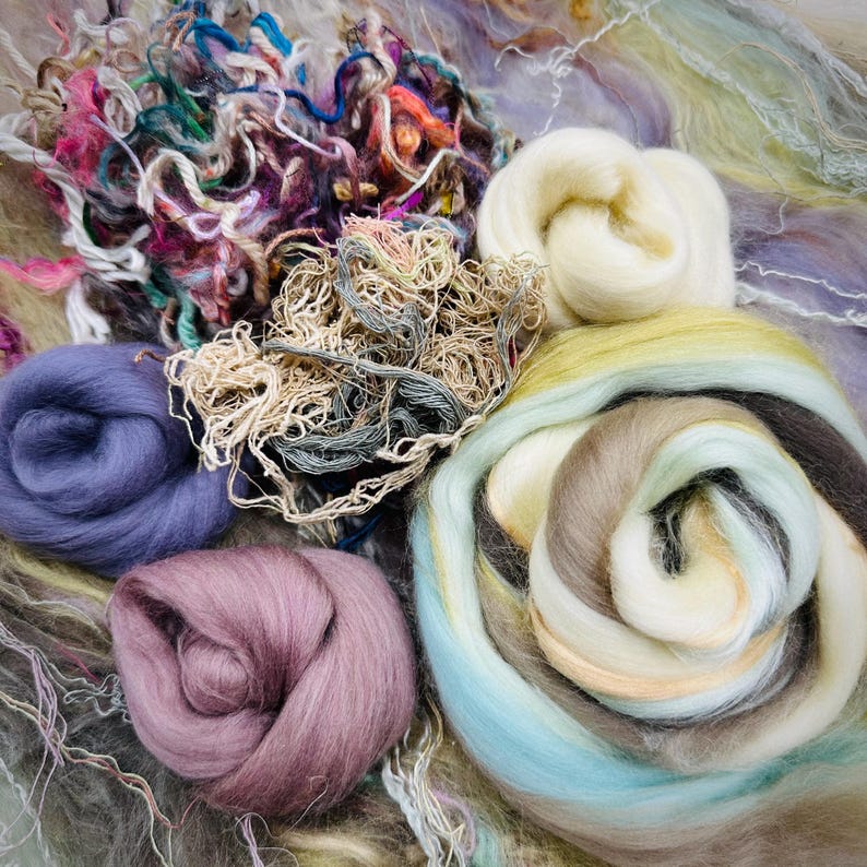 May include: A collection of colorful wool roving in various shades of blue, purple, brown, white, and green. The wool is arranged in a loose, swirling pattern, creating a visually appealing and textured display.