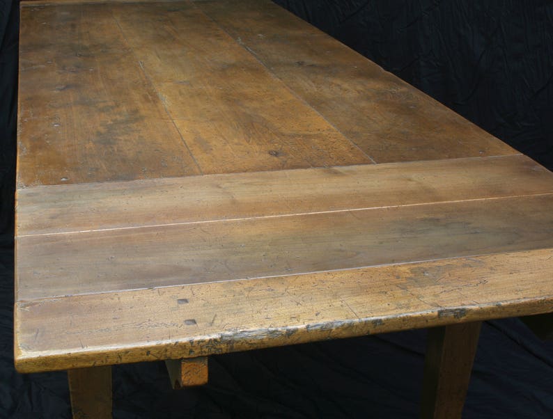 Puede incluir: Una mesa de madera r&uacute;stica con un acabado de madera natural. La superficie de la mesa est&aacute; hecha de varias tablas de madera que se han unido. La mesa tiene un dise&ntilde;o simple con una superficie rectangular y cuatro patas.