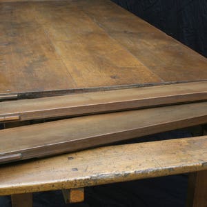 Puede incluir: Una mesa de madera con una extensi&oacute;n de hoja ca&iacute;da. La mesa est&aacute; hecha de madera marr&oacute;n oscura y tiene un acabado r&uacute;stico. La mesa est&aacute; en posici&oacute;n cerrada, con la hoja ca&iacute;da plegada hacia abajo.