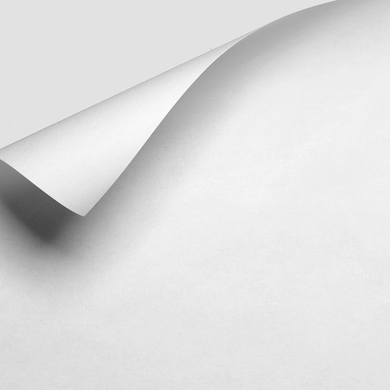 Puede incluir: Una hoja de papel blanca con una esquina doblada, creando una sombra en la superficie del papel.