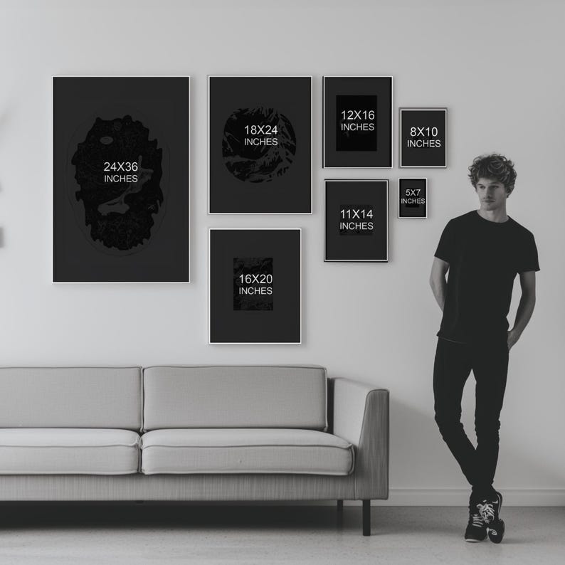May include: A white wall with a gray couch in front of it. There are nine black frames with white text on them, each showing different sizes of prints. The text in the frames reads: 24x36 inches, 18x24 inches, 12x16 inches, 11x14 inches, 16x20 inches, 8x10 inches, 5x7 inches.