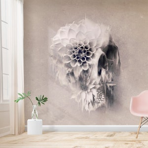 May include: A sepia-toned wall mural featuring a skull design overlaid with large, detailed flowers. The flowers are white and gray, creating a striking contrast against the textured background. The room includes a window, a vase with greenery, and a pink chair.
