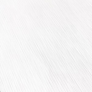 May include: A close-up shot of a white surface with a textured, linear pattern. The lines run diagonally across the frame, creating a sense of depth and visual interest. The texture appears to be slightly raised, adding to the tactile quality.