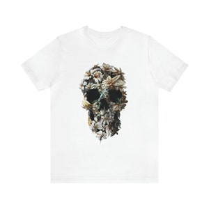 May include: White t-shirt featuring a floral skull design. The skull is composed of white, yellow, and brown flowers.