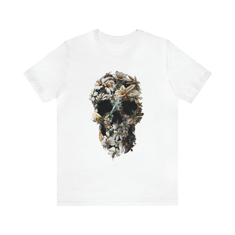 May include: White t-shirt featuring a floral skull design. The skull is composed of white, yellow, and brown flowers.