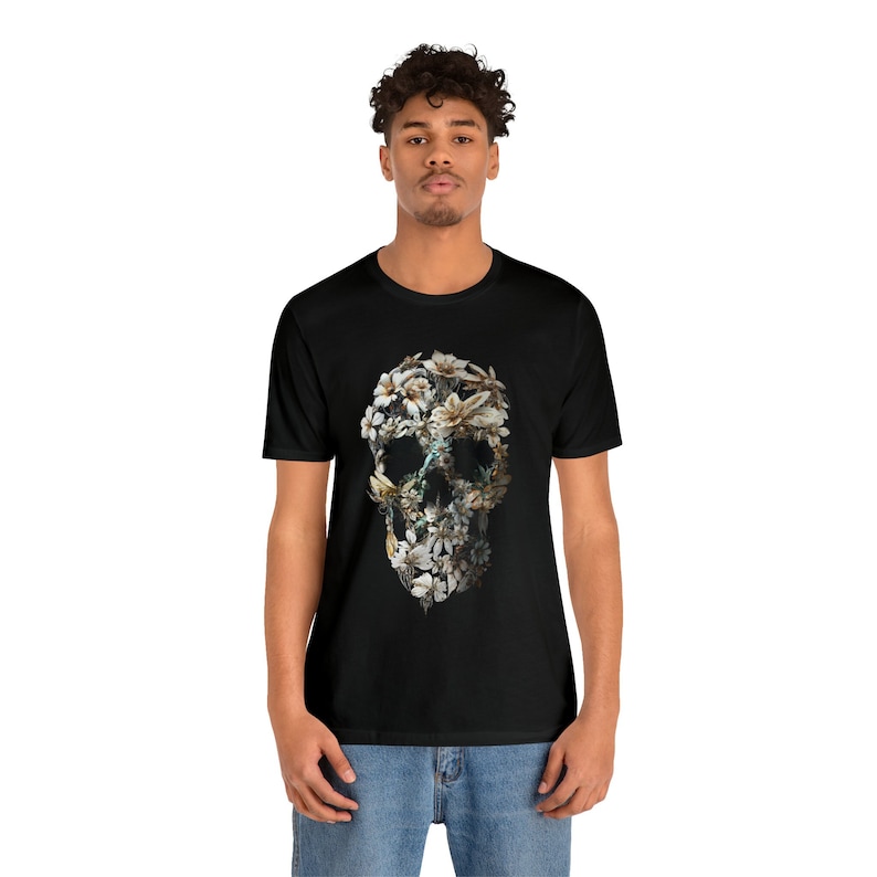 May include: A black t-shirt featuring a floral skull design. The skull is composed of white and yellow flowers.