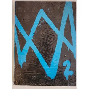 May include: A black book with a blue graffiti-style design and the number 2. The cover has a repeating skull pattern and is wrapped in plastic. The blue design appears to be a stylized letter or symbol.