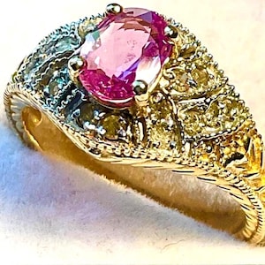 Genuine Pink Sapphire ring set in 10kt yellow Gold with Diamond accents.  Size 6.5
