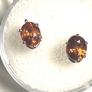 7 x 5mm. Oval, Orange, Red, Spessartite Garnet, Post Earrings in Sterling Silver. 0.9 Carats Total Gem Weight.