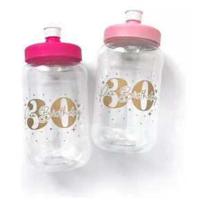 May include: Two clear plastic water bottles with pink lids and gold lettering that says "30th Birthday".