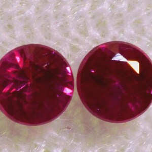 以下が含まれることがあります： ファセットカットされた丸い明るいピンクの宝石が2つ。宝石は白い背景に置かれています。