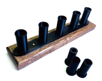 May include: A wooden rack with six black cylindrical holders. The rack has a dark brown finish and a black strip running down the center. Three additional black holders are placed below the rack.
