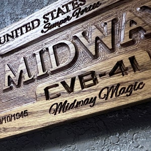 May include: A wooden sign with the words "United States Semper Fortis" and "Midway CVB-41 Midway Magic" engraved on it. The date "09/10/1945" is also engraved on the sign.