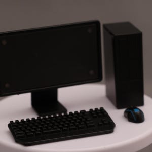 May include: A black desktop computer set consisting of a flat-screen monitor, a vertical tower case, a keyboard, and a computer mouse with blue accents. The components are arranged together as a complete workstation unit for computing tasks.