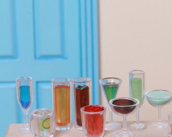 May include: A collection of miniature glass drinkware, including a martini glass, shot glasses, and a highball glass. The glasses are filled with colourful liquids, such as red, green, and blue.