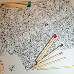 May include: A black and white intricate coloring page with a floral design.  The page is surrounded by wooden colored pencils, some with red, brown, and pink tips.