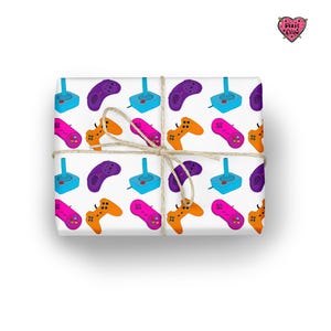 May include: White wrapping paper with a repeating pattern of colorful video game controllers. The controllers are in shades of purple, orange, pink, and blue. The paper is tied with twine.