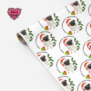 May include: White wrapping paper roll with a repeating pattern of pugs wearing Santa hats, surrounded by holly and ornaments. The text "Have a Pugtastic Christmas" is printed around each pug. The Pixie Drew logo is in the upper left corner.