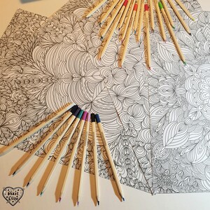 May include: A close-up of a coloring book page with intricate patterns and a variety of colored pencils arranged around it. The pencils are wooden and have a natural finish.