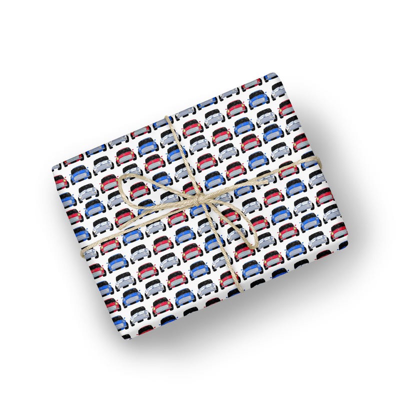 May include: White wrapping paper with a repeating pattern of red, blue, and white cars. The paper is tied with twine.