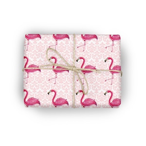 May include: Pink flamingo gift wrap with a white damask pattern. The wrapping paper is tied with twine.