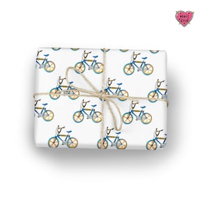 May include: White wrapping paper with a repeating pattern of blue and yellow bicycles. The paper is tied with twine.