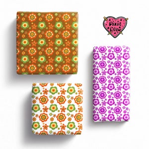May include: Three rectangular blocks wrapped in patterned paper. One block has a brown background with orange and green flowers. Another has a white background with orange and green flowers. The third is white with purple flowers. A heart logo reads Pixie Drew.