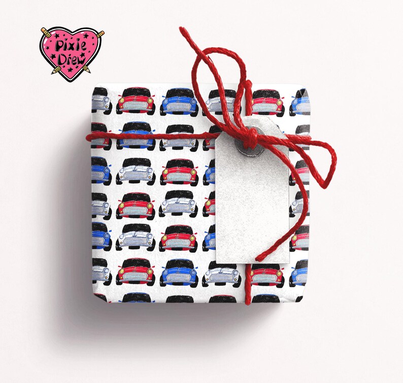 May include: A white gift box with a red ribbon and a tag. The box is wrapped in paper with a pattern of red, blue and white cars.