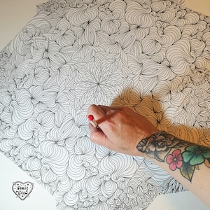 May include: A black and white intricate line drawing of swirling patterns and shapes. A hand is holding a red pencil over the drawing.