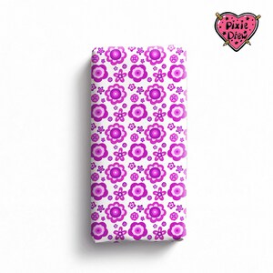 May include: A rectangular fabric swatch featuring a repeating pattern of magenta and light pink flowers on a white background. In the top right corner, a pink heart-shaped logo displays the text Pixie Drew with two crossed pencils.
