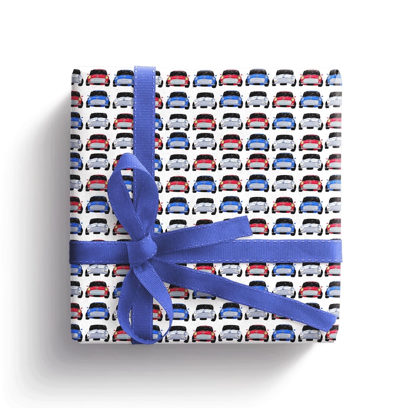 May include: White gift wrap with a repeating pattern of red, blue and white miniature cars. A blue ribbon is tied around the gift wrap.