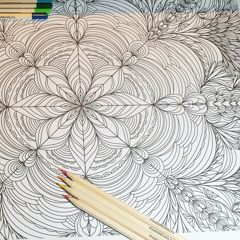 May include: A black and white intricate mandala design coloring page with a set of colored pencils on top of the page. The pencils are wooden and have a natural finish.