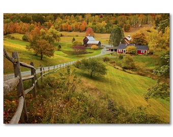 Puede incluir: Una vista panorámica de un paisaje rural con una granja roja y una valla de madera en primer plano. Los árboles están en colores otoñales, con tonos de rojo, naranja y amarillo. El camino conduce hasta la granja, que está rodeada de hierba verde y árboles.