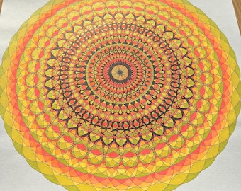 May include: A circular mandala drawing on white paper featuring intricate, overlapping geometric patterns in shades of yellow, orange, and lime green. The design consists of concentric rings of fine black ink lines, creating a complex, symmetrical, and radial floral-like structure that radiates from a dark central point.