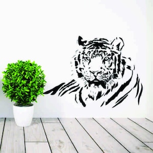 May include: Black and white silhouette of a tiger's head and shoulders. The tiger is facing forward with its mouth closed. The background is white.
