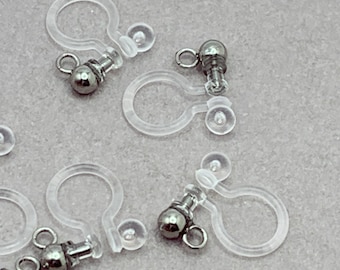May include: A set of six clear plastic earring backs with silver ball closures. The backs are designed to be used with clip-on earrings.