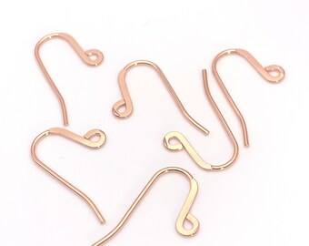 May include: Five rose gold earring hooks, each with a small loop at the top and a curved hook at the bottom.