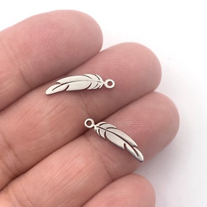 May include: Two silver feather charms with a loop for attaching to jewellery or other crafts.