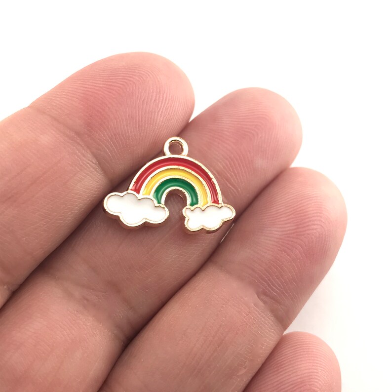 May include: Gold-tone rainbow charm with red, yellow, and green enamel. The rainbow is accented with two white clouds.