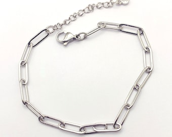 May include: A silver chain bracelet with a lobster clasp and a small clear crystal charm.