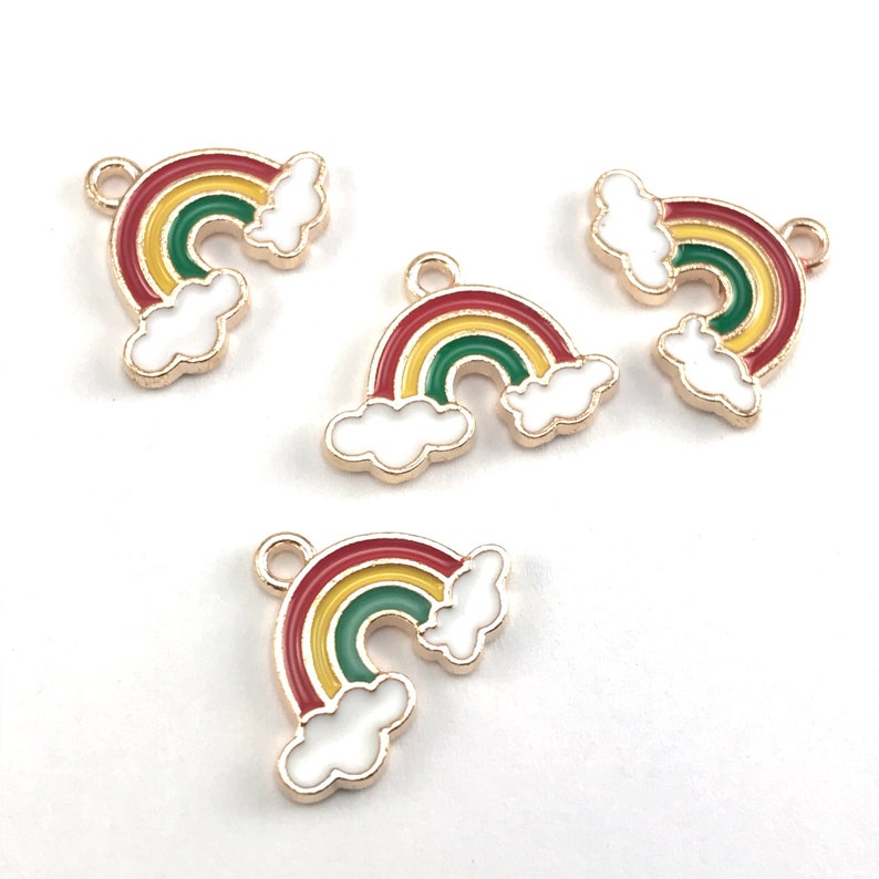 May include: Four gold-tone rainbow charms with white clouds. Each charm features a red, yellow, and green rainbow with a gold-tone loop for attaching.