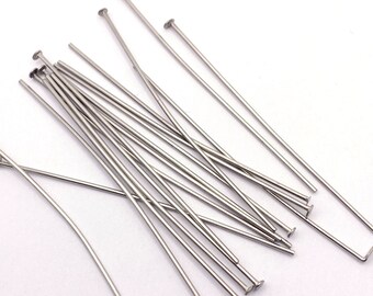 May include: A pile of silver-toned head pins, also known as jewellery making pins, with a flat head. These pins are used for attaching beads, charms, and other jewellery components.