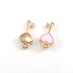 May include: Two gold-colored key charms with heart-shaped heads. One charm has a gold heart, and the other has a pink heart.