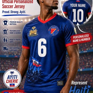 May include: A dark blue soccer jersey featuring the number 6 in white on the chest, a red collar and sleeve trim, the Haiti national emblem, and a graphic of people holding the Haitian flag. The back displays the number 10 and text YOUR NAME.