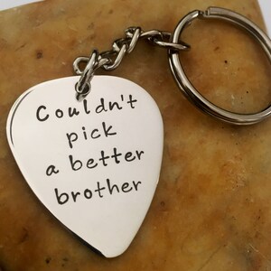 Può includere: Portachiavi a forma di plettro per chitarra in argento con inciso il testo "Couldn't pick a better brother".