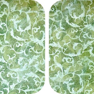 May include: Two oval-shaped decorative panels with a watercolor-style design. The background is a blend of green and yellow hues, overlaid with a white, swirling, floral pattern. The overall effect is a vintage, artistic aesthetic.