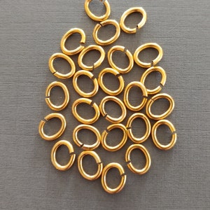 Könnte beinhalten: Ein Haufen von 25 goldfarbenen ovalen Sprungringen. Die Sprungringe haben einen Durchmesser von etwa 1,25 cm.