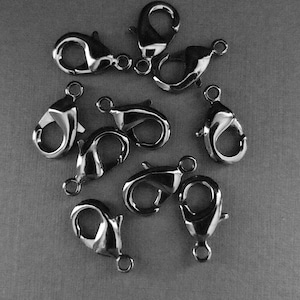 May include: Ten black metal lobster clasps, a type of fastener used for jewelry making.